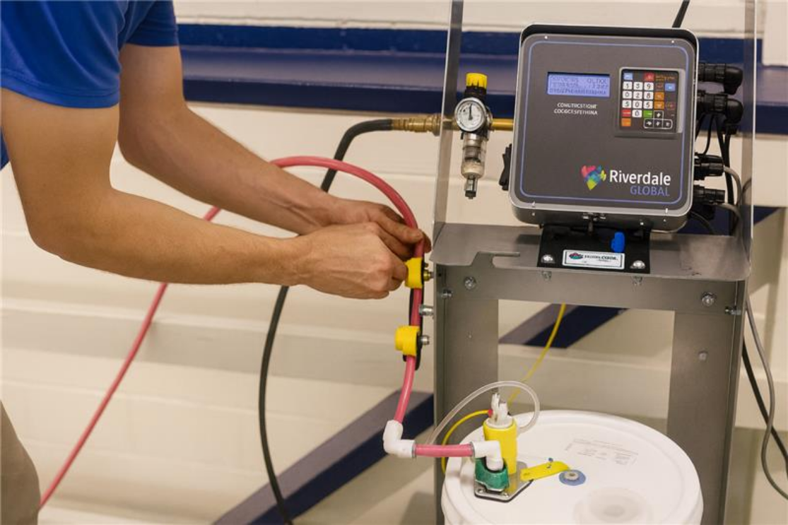 Technician connecting a sealed line to a liquid color pail